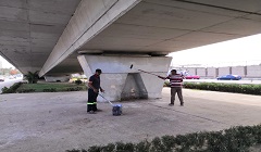 دهان اعمدة وحوائط كوبري المطار بمحور العروبة بأيدي نقاشين الورش الإنتاجية