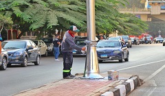 طلاء أعمدة الإنارة في شارع الثورة بحي مصر الجديدة